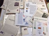 a pile of papers on a table with a laptop on top of it