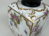 a white and gold vase with flowers on it