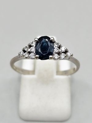 a white gold ring with a blue sapphire and diamonds