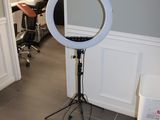 une photo d'une pièce avec un miroir et une lampe posée sur un trépied