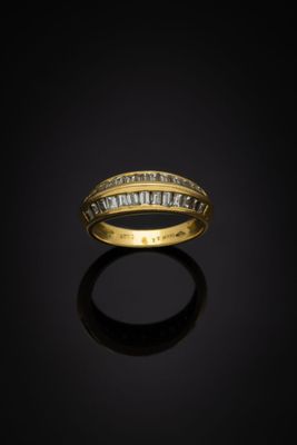 une bague en or sertie de diamants taille baguette sur fond noir