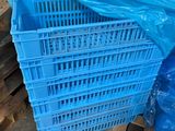 une caisse en plastique bleue posée sur une palette dans un entrepôt
