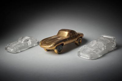 trois petites voitures en plastique posées les unes à côté des autres sur une table