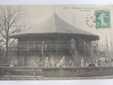 une carte postale sur laquelle figure la photo d'un bâtiment avec des personnes