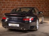 a black sports car parked in front of a brick wall