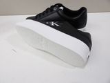 a close up of a pair of black and white sneakers on a table