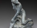 l'image d'une statue de femme assise sur un rocher