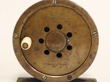 a close up of a small fishing reel on a stand