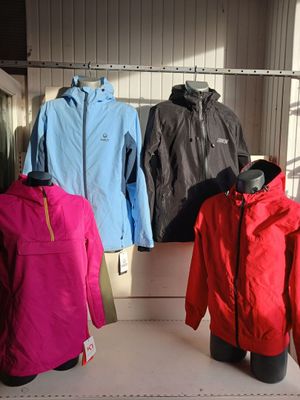 several jackets are displayed on a rack in a clothing store