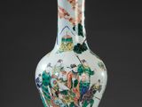 un vase blanc orné d'un motif vert et rouge