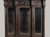 une image représentant une vitrine en bois dotée de portes vitrées et de sculptures