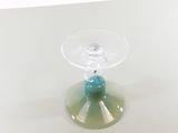a clear glass cup with a blue candle inside of it