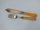 two forks and a knife on a white surface