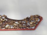 a gold and red piece of art on a white surface
