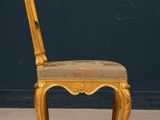 an antique chair with a gold finish and a floral upholstered seat