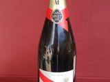 une bouteille de champagne posée sur une table rouge, avec un fond rouge