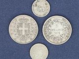 three different types of silver coins on a blue cloth