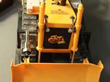 a toy bulldozer sitting on a desk next to a keyboard