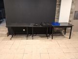 two black tables and a black wall in a room