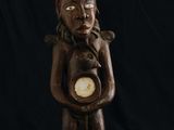 un gros plan sur la statue d'une personne tenant une horloge