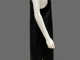 mannequin dressed in a black dress and white sneakers on a gray background