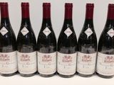 six bouteilles de vin sont alignées sur une table