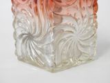 a glass vase that has a swirl design on it