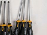four screwdrivers are lined up in a row on a white surface