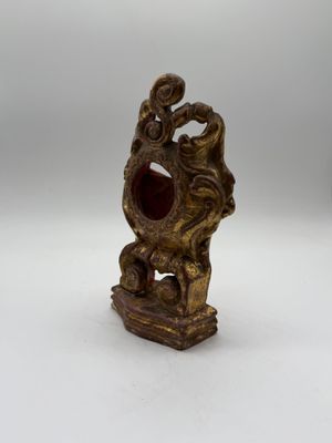 a close up of a small statue of a dragon on a white surface