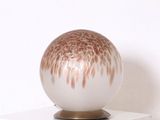un vase blanc et marron posé sur une étagère blanche