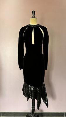 une robe noire avec un nœud jaune sur un mannequin