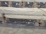 de nombreux matelas empilés les uns sur les autres dans un entrepôt