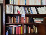 a book shelf with many books on it in a room