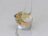 a gold ring with a black stone in it