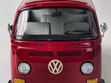 a red vw bus that is parked on a white surface