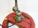 a red and green fire hydrant sitting on top of a wooden stand