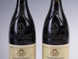 two bottles of red wine sitting next to each other on a table