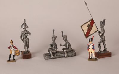 four figurines of soldiers with a flag and a flag pole