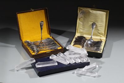 deux cuillères en argent et une cuillère en argent dans une boîte posée sur une table