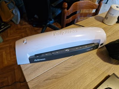 une photo d'une agrafeuse posée sur une table à côté d'un ordinateur portable
