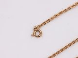 a close up of a gold chain on a white surface