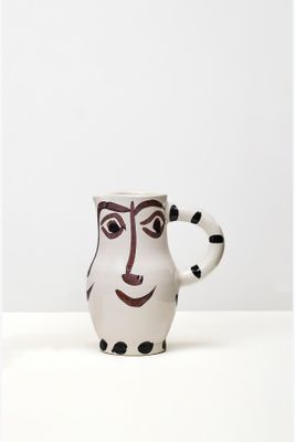 une image représentant un mug en céramique sur lequel est peint un visage