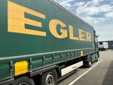 un gros camion vert garé sur un parking