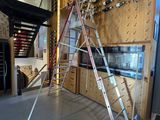 a ladder that is sitting in front of a wall of wine bottles