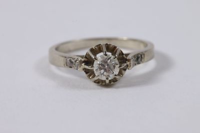 gros plan d'une bague en diamant sur une surface blanche