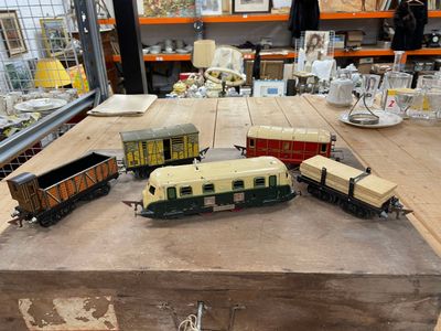 Plusieurs petits trains sont posés sur une table en bois dans une pièce.