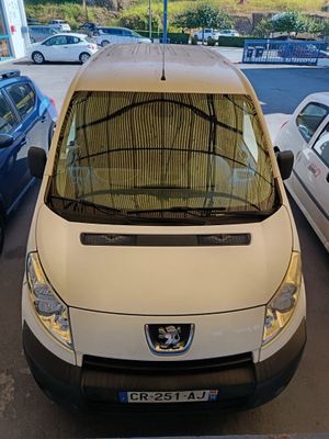 une camionnette blanche garée dans un parking à côté d'autres voitures