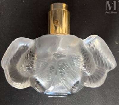 an image of a clear glass perfume bottle with a gold top