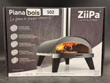 La boîte du four à pizza est ouverte et prête à être mise au four.