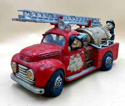 a toy fire truck with a barrel on the back of it